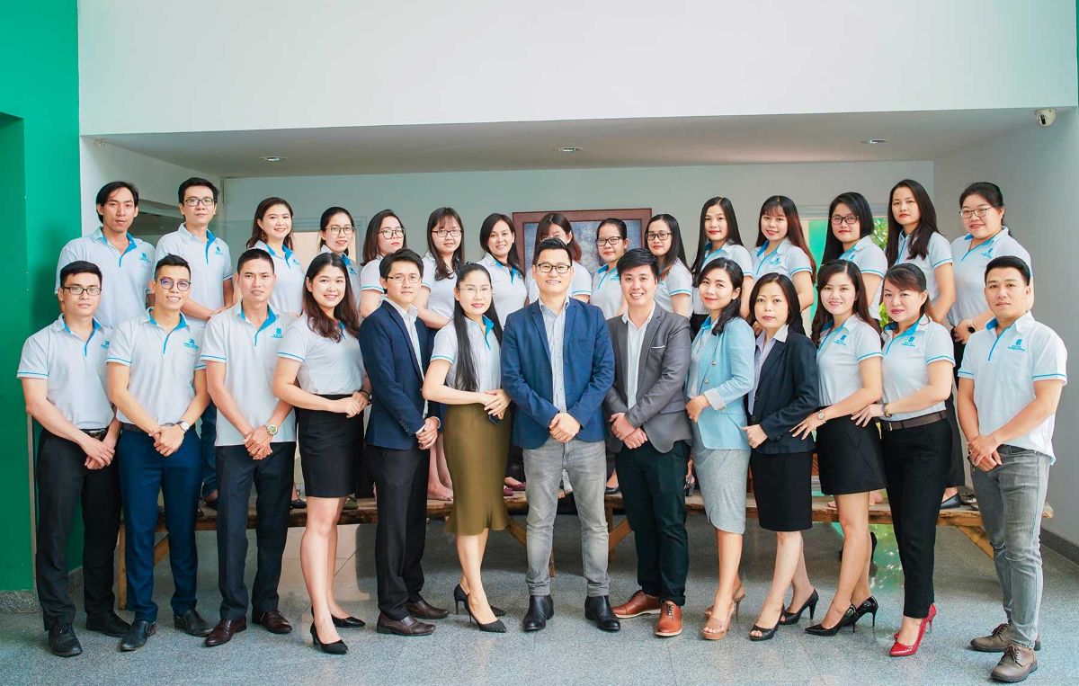 Tập thể nhân viên Kiểm toán Hoàng Gia Việt Nam mặc đồng phục tại sảnh văn phòng