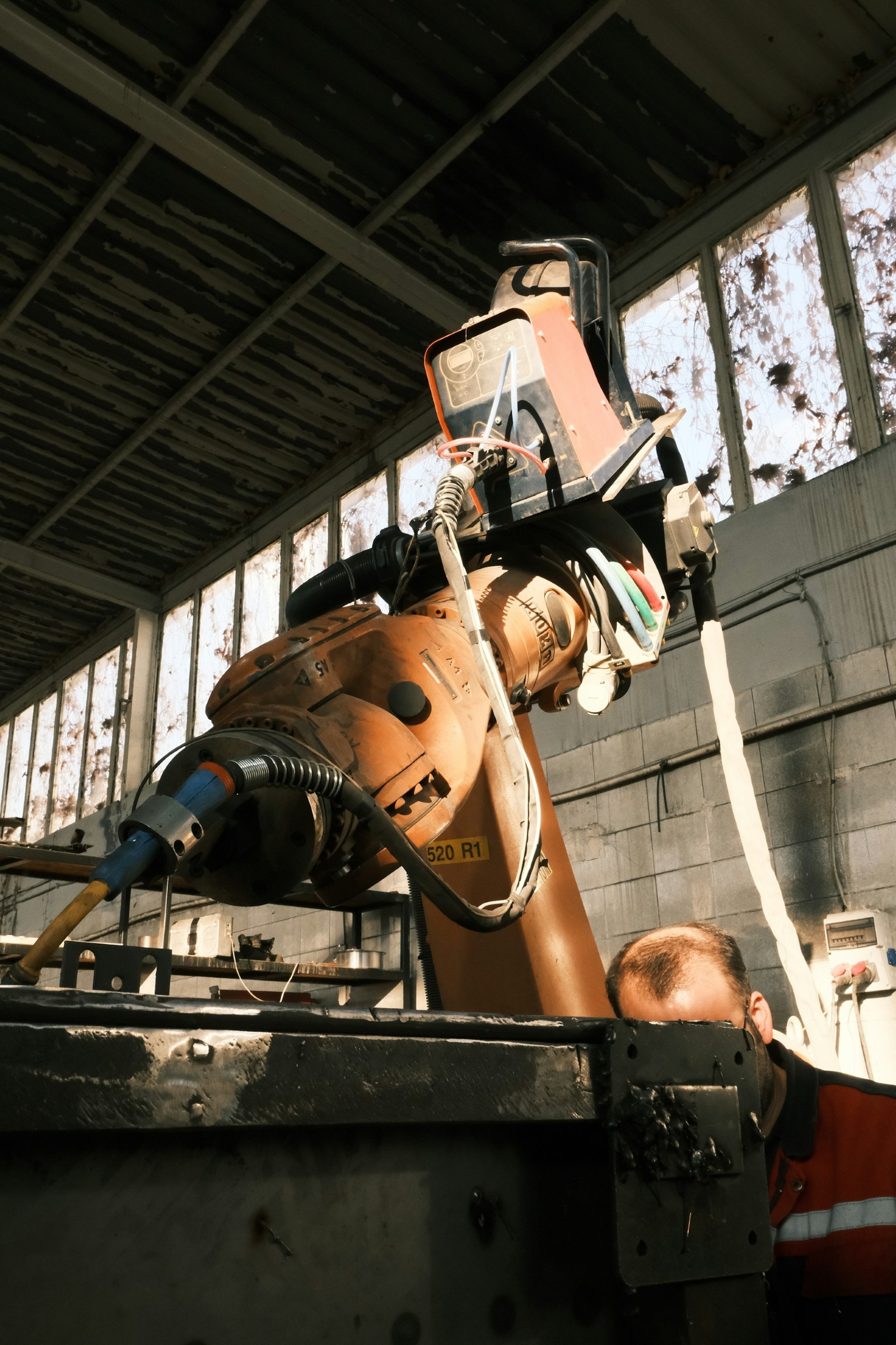 Cánh tay robot hàn làm việc trong xưởng sản xuất cơ khí